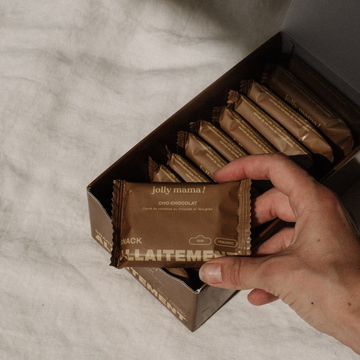 hand taking a breastfeeding chocolate snack out of a box