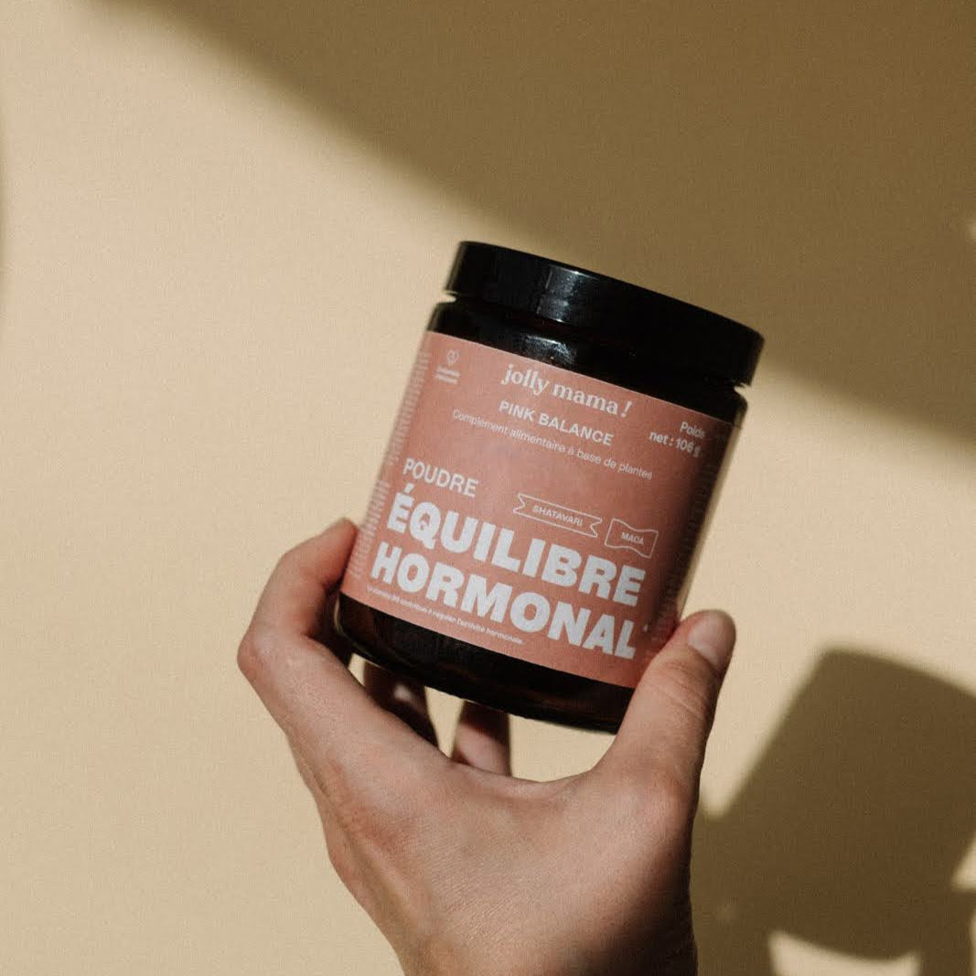 a woman's hand holding a pot of Pink Balance, a powder for hormonal balance
