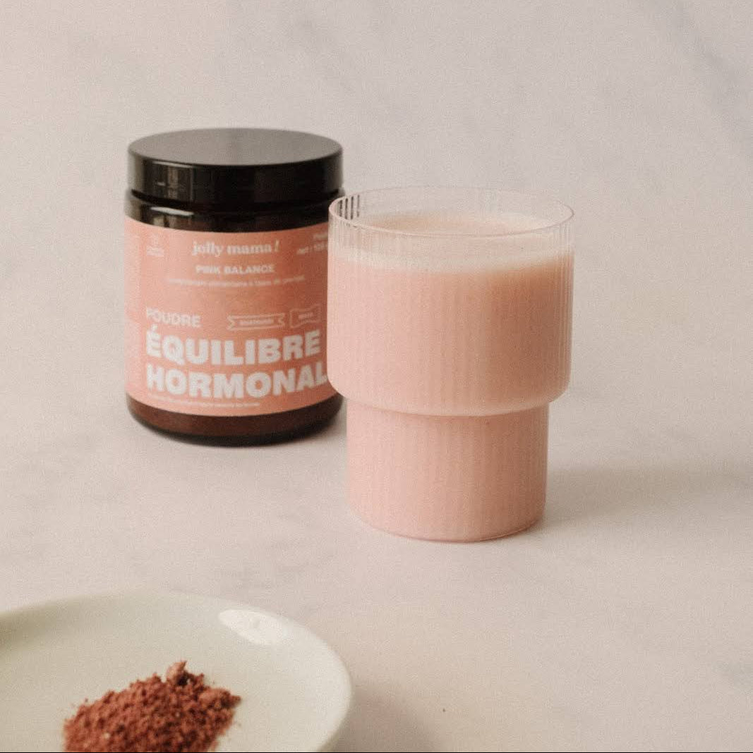 glass with Pink Balance powder mixed with plant-based milk, pale pink colour