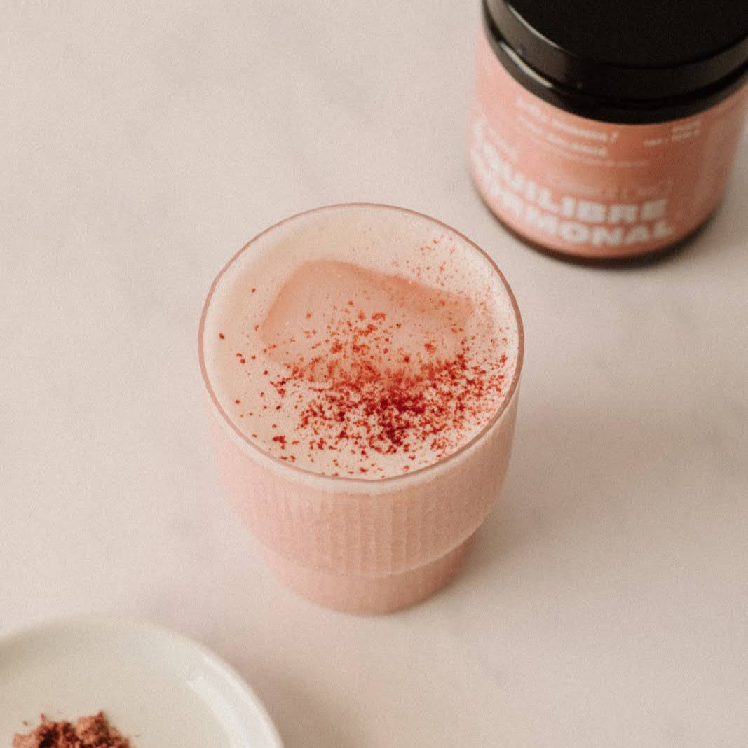 Glass containing Pink Balance powder, prepared with a plant-based milk