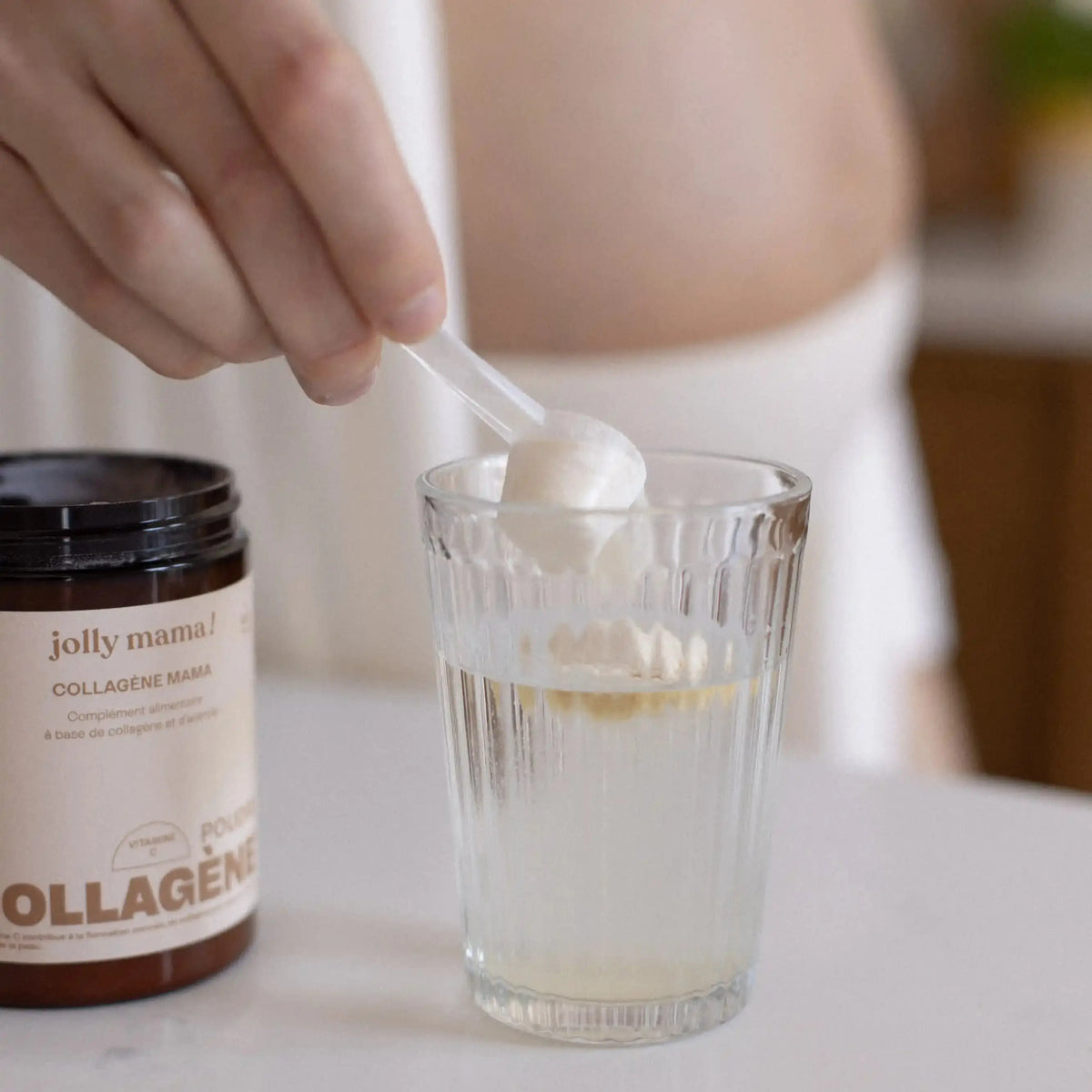 femme enceinte mélangeant collagène mama dans un verre