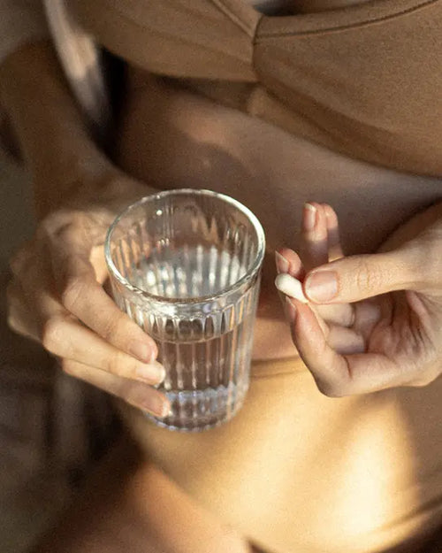 femme qui prend une gélule pour la pousse des cheveux
